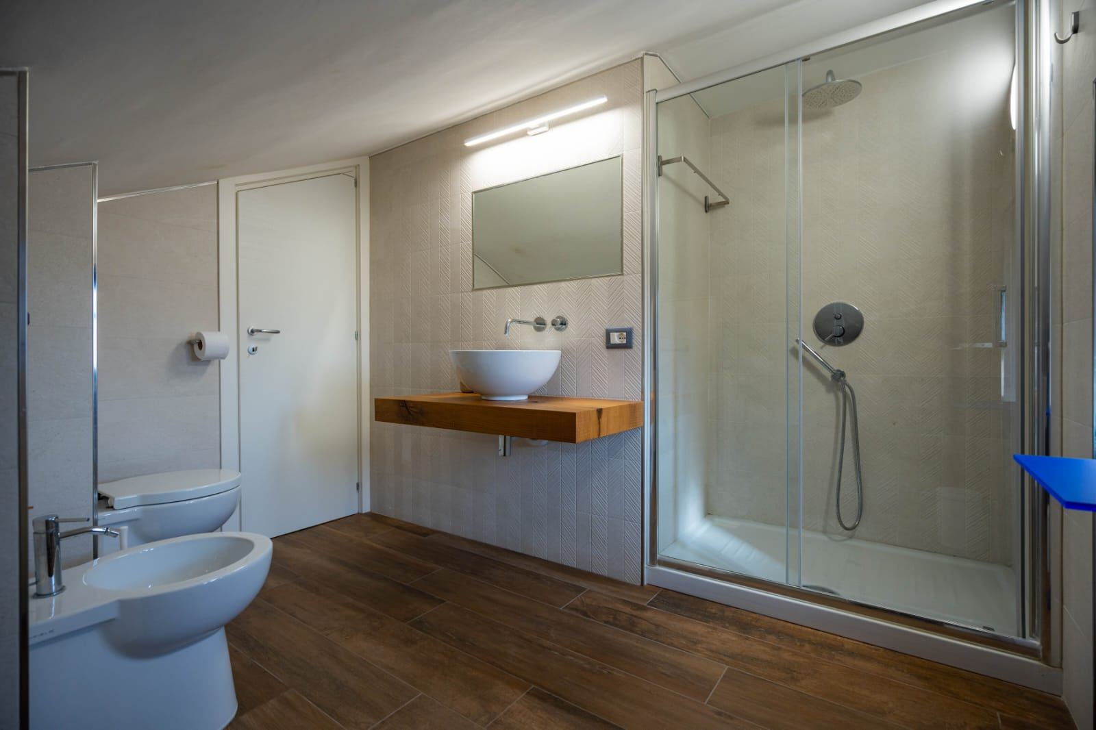 Bagno privato della Camera Ulisse con doccia e lavabo in legno