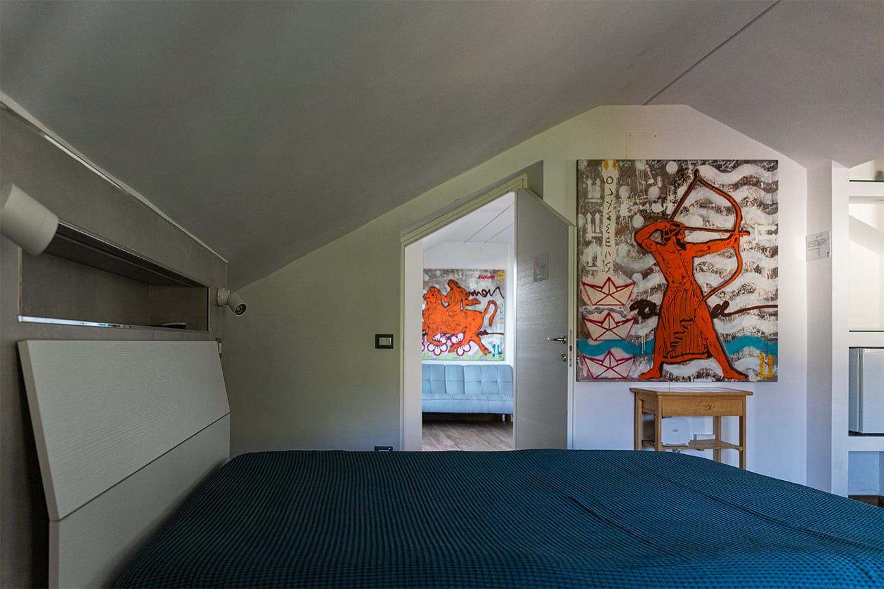 Camera Zeus con letto matrimoniale sotto il soffitto a mansarda del B&B Mythos