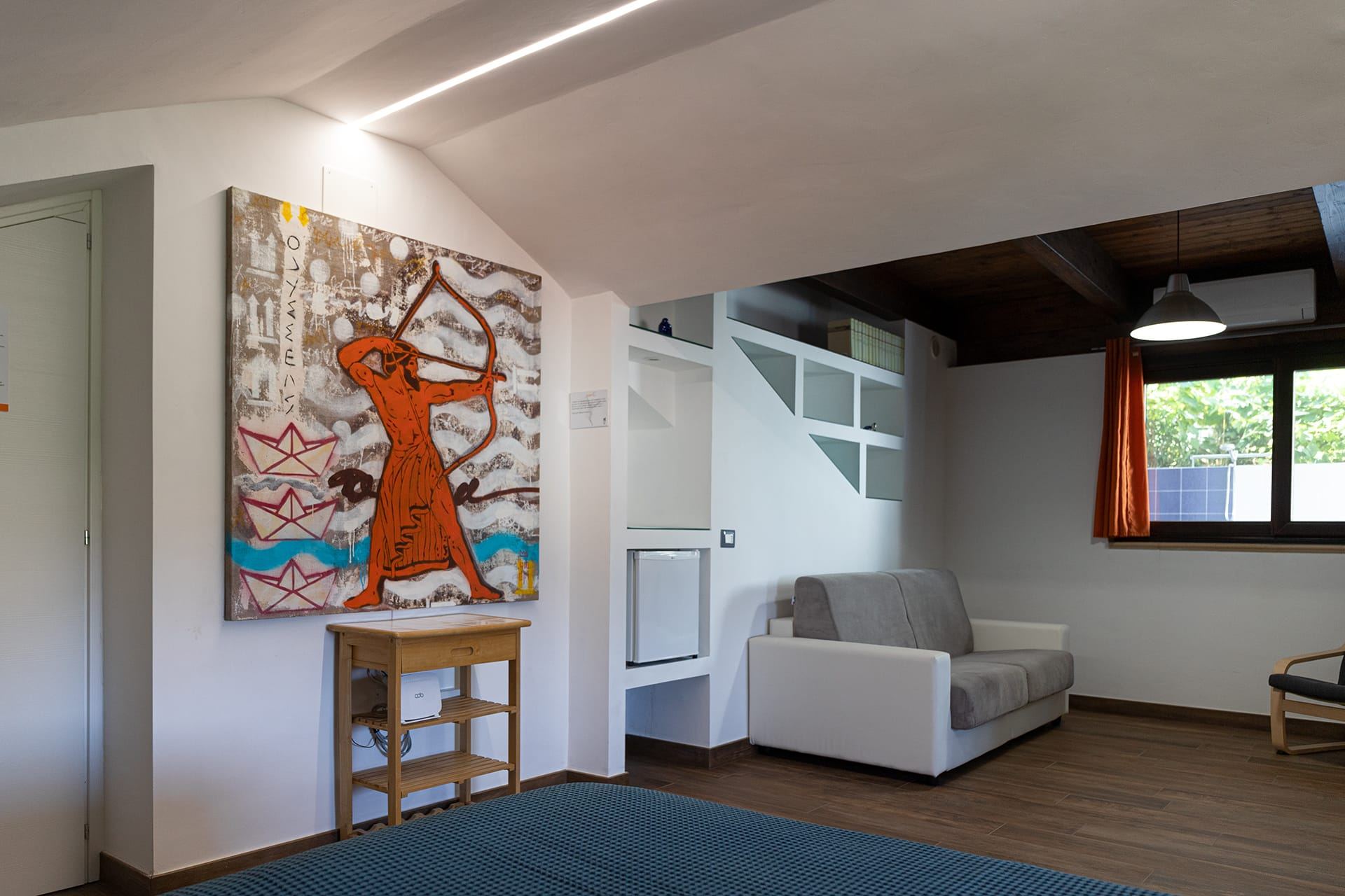 Soggiorno luminoso del B&B Mythos con opera d'arte a tema mitologico e arredi di design